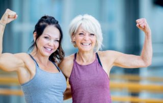 zwei fitte mädels posieren im fitnesstudio
