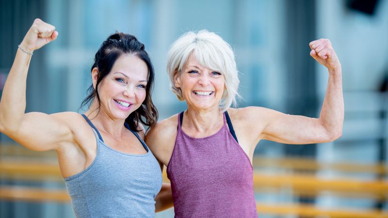 zwei fitte mädels posieren im fitnesstudio