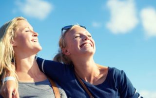 zwei blonde junge mädchen geniessen die sonne