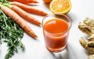 frisches obst und gemüse mit einem vitamindrink liegen auf einer weissen oberfläche